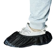 a person standing on top of a black shoe cover