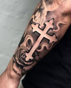 a man with a cross tattoo on his arm