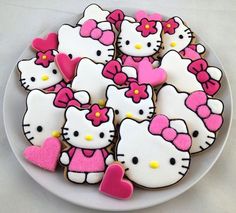 hello kitty cookies are arranged on a white plate with pink and yellow hearts in the middle