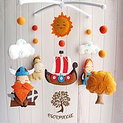 three felt mobiles hanging on a white wall with clouds, sun and boat in the sky