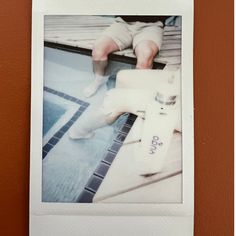 a polaroid photograph of a baby's feet on a tile floor