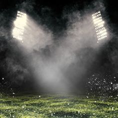 an empty soccer field with fog and spotlights