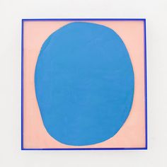 a blue circle on a pink square in front of a white wall