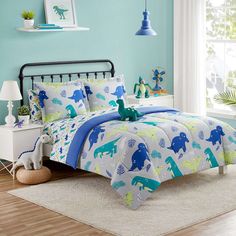 a bed room with a neatly made bed and a toy dinosaur on the comforter