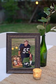 a table with a vase, candle and photo on it