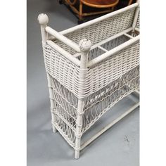 a white wicker magazine rack with handles