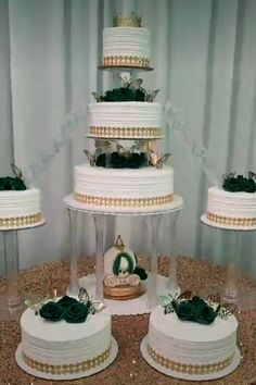 three tiered wedding cake sitting on top of a table with other cakes in the background