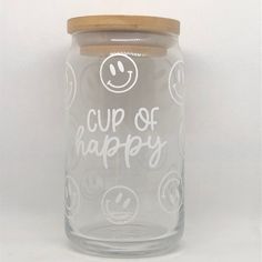 a glass jar with the words cup of happy written on it and smiley faces drawn on it