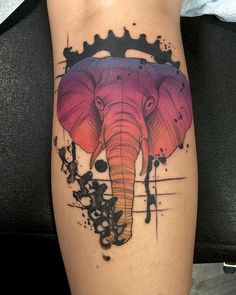 an elephant tattoo on the leg with paint splattered around it's head