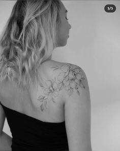 the back of a woman's shoulder with flowers on it