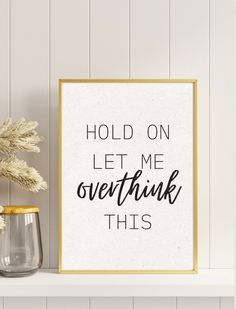 a white and gold framed sign that says hold on let me overthik this