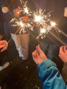 people are holding sparklers in their hands