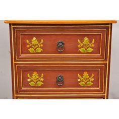 an old wooden dresser with painted flowers on the drawers and knobs inlayed to it's sides