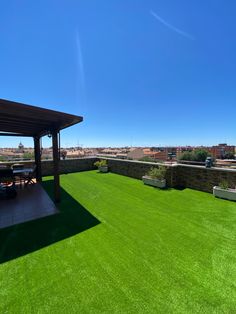 an outdoor patio with green grass and blue sky