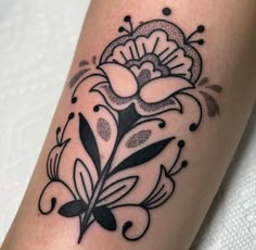 a black and white flower tattoo on the leg