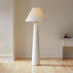 a white lamp sitting on top of a wooden floor