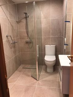 a bathroom with a toilet, shower and sink in it's stall door area