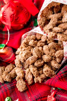 two bags filled with cookies sitting on top of a plaid table cloth next to christmas decorations