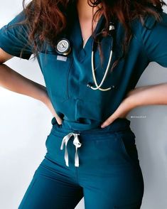 a woman in scrubs is posing with her hands on her hips