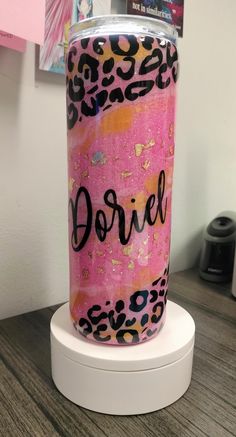 a pink and black leopard print tumbler with the word dorriel on it