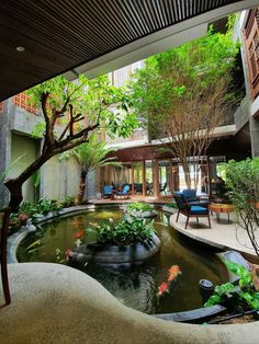 an outdoor patio with a pond and seating area