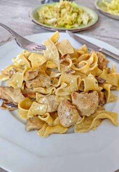 a white plate topped with pasta and chicken