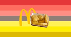 a mcdonald's box filled with doughnuts next to a rainbow - striped background