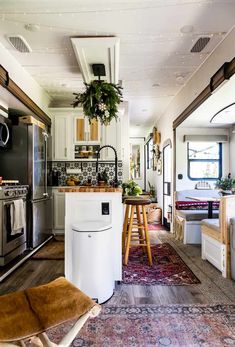 a kitchen and living room with an area rug on the floor in front of it