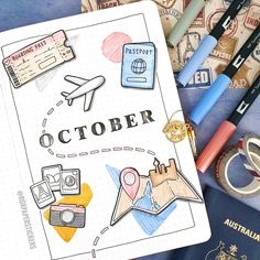 an open notebook sitting on top of a table next to travel related items and passport