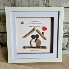 a white frame with some rocks in it and a star on the wall behind it