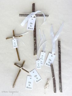 the cross is made out of sticks with tags attached to it and tied in twine