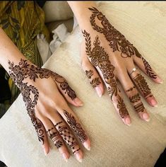 two hands with henna tattoos on them