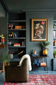 a living room with dark blue walls and lots of bookshelves on the shelves