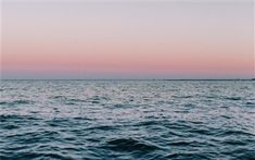 the ocean is very calm at sunset with no one in sight or any other boat