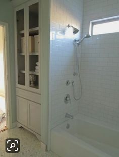 a bathroom with a shower and white tile flooring next to an open door that leads to a walk in closet