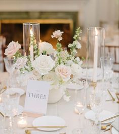 there is a centerpiece with flowers and candles on the table at this wedding reception