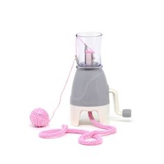 a pink ball of yarn next to a blender with a hook on the handle