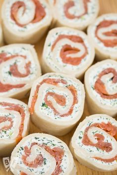 small rolls filled with meat and cheese on top of a wooden table