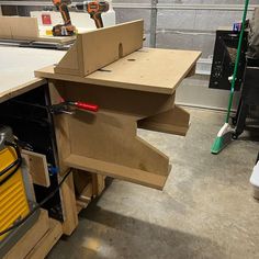 a workbench with tools on it in a workshop area, including a router and drill box