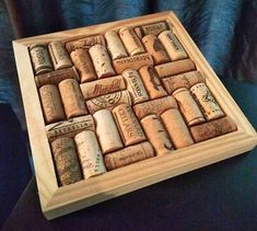 a wooden box filled with wine corks on top of a blue cloth covered chair