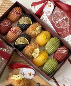 two boxes filled with assorted pastries on top of a table