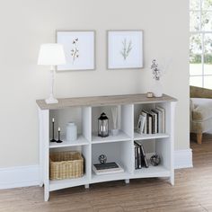 a white shelf with books and pictures on it