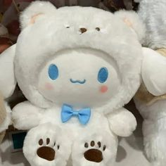 two white teddy bears sitting next to each other with blue eyes and bows on their heads