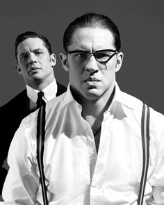 black and white photograph of two men wearing glasses, one with his hands on his hips