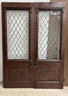 two wooden doors with glass panels on them