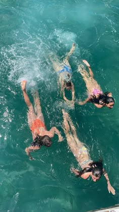 three people are swimming in the water near each other on their stomachs and arms