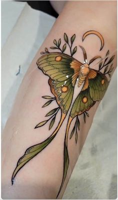 a small butterfly tattoo on the arm with flowers and leaves around it's wings