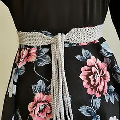 a woman's black and pink flowered dress with white lace trimmings