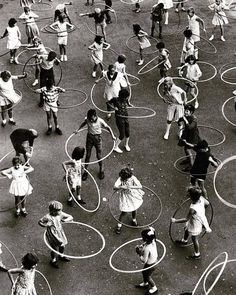 an aerial view of children playing with hula hoop's in a playground area