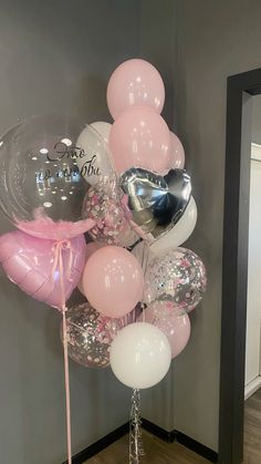 a bunch of balloons that are in the shape of a heart and some words on them